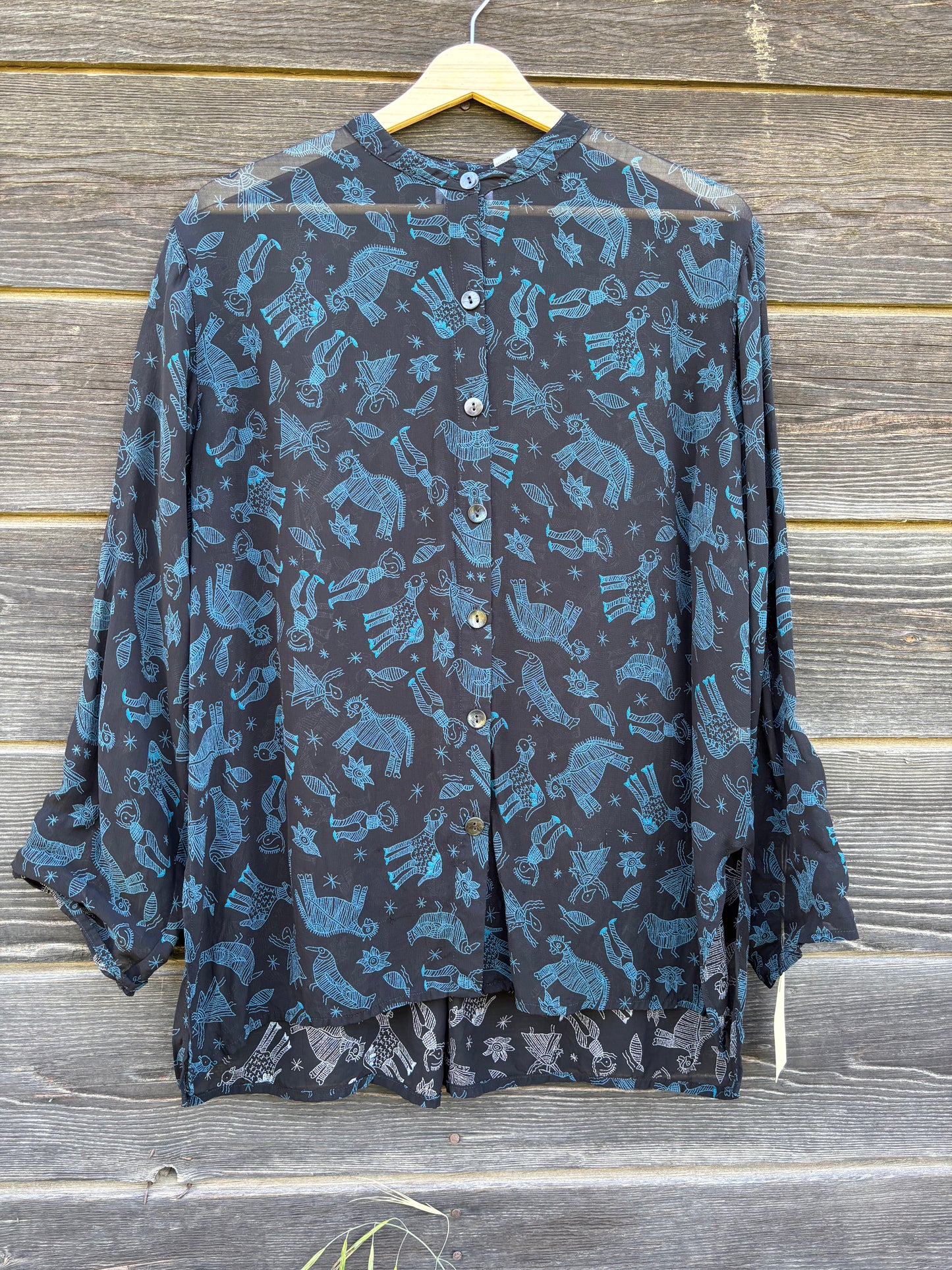 Sheer black blouse with celestial and animal sketches.
